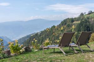 zwei Stühle auf einem Hügel mit Aussicht in der Unterkunft Ritschhof in Lajen