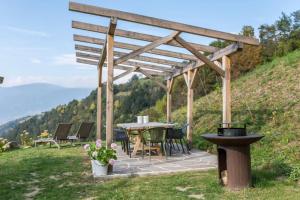 eine Terrasse mit einem Tisch und Stühlen auf einem Hügel in der Unterkunft Ritschhof in Lajen