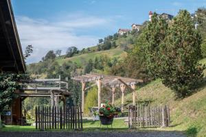 a garden with a wooden fence and flowers on a hill at Ritschhof in Laion