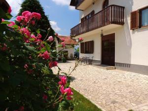 a courtyard with pink roses in front of a building at Casa da Emanuela in Drežnik Grad +8 photos