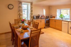 a large kitchen with a wooden table and chairs at Hillside Cottage in Aberdeen