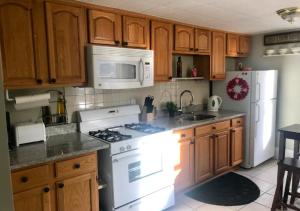 a kitchen with white appliances and wooden cabinets at Spacious 2 Bed 1 Bath In Mid West in New York