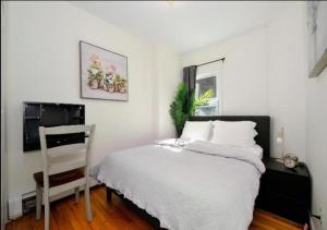 a bedroom with a bed and a chair and a television at Spacious 2 Bed 1 Bath In Mid West in New York