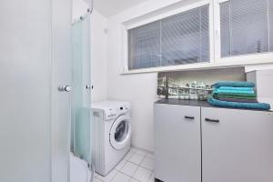a white laundry room with a washer and dryer at Destiny apartment in Bratislava