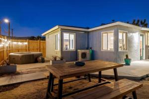 a backyard with a wooden table and a house at Audreys Place - Hot tub - Fire Pit - Downtown JT in Joshua Tree