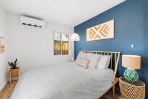 a bedroom with a large bed with a blue wall at Audreys Place - Hot tub - Fire Pit - Downtown JT in Joshua Tree