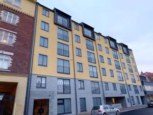 a yellow building with a car parked in front of it at New AC Studio City Center. in Turku