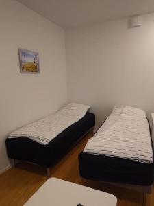two twin beds in a room with a wall at New AC Studio City Center. in Turku +2 photos