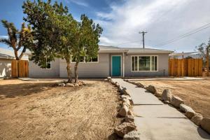 a house with a tree in the yard at Audreys Place - Hot tub - Fire Pit - Downtown JT in Joshua Tree +27 photos