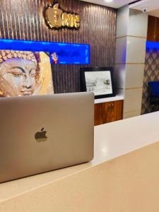 laptopa siedzącego na ladzie w sklepie w obiekcie Hotel Apple Inn n Suites, New Delhi w Nowym Delhi