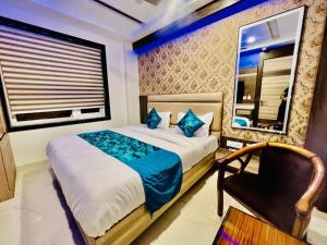 um quarto com uma cama, uma janela e uma cadeira em Hotel Apple Inn n Suites, New Delhi em Nova Deli