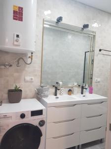 a bathroom with a sink and a washing machine at Mar y Sol Suites in Grao de Castellón
