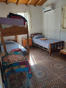 een slaapkamer met 2 stapelbedden en een tapijt bij Finca Las Acacias in Maipú