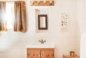 een badkamer met een wastafel en een spiegel bij Casa de la Muxer - 940s Adobe - Hot Tub - Cowboy Pool in Twentynine Palms