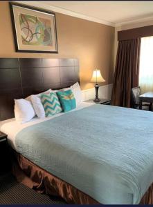 a bedroom with a large bed with blue sheets and pillows at Morro Crest Inn in Morro Bay
