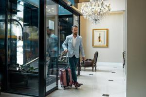a man is pulling a suitcase in a lobby at Amérian Executive Córdoba Hotel in Córdoba