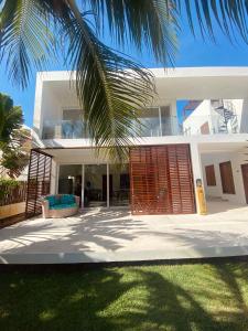 瓜吉魯的住宿－BEACH VILLA Camurupim，前面有棕榈树的白色房子