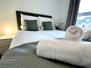 a bedroom with a large white bed with a window at Dale House by Blue Skies Stays in Middlesbrough