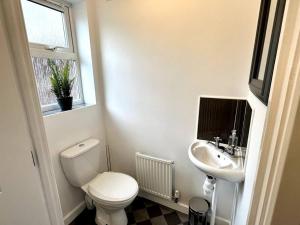 a white bathroom with a toilet and a sink at Dale House by Blue Skies Stays in Middlesbrough