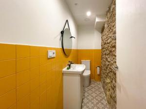 a bathroom with a sink and a toilet and a mirror at San Isidoro Coliving in Oviedo
