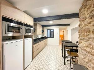 a kitchen with a white refrigerator and a table at San Isidoro Coliving in Oviedo
