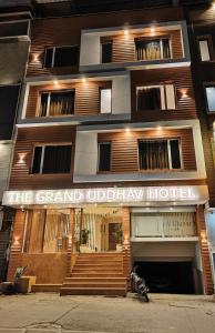 The Grand Uddhav - A Boutique Hotel في أودايبور: مبنى عليه لافته مكتوب عليها فندق مظله كبيره