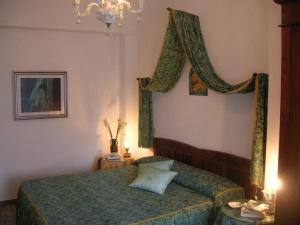 - une chambre avec un lit et un lustre dans l'établissement Hotel Rosati, à Chiusi
