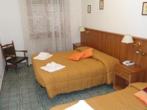 una camera d'albergo con due letti e una sedia di Hotel Rosati a Chiusi