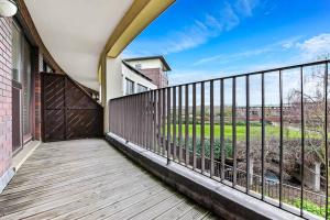 a balcony with a wooden railing and a fence at Scenic Park View Suite in Milton Keynes