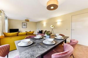 a living room with a table with chairs and a couch at Scenic Park View Suite in Milton Keynes
