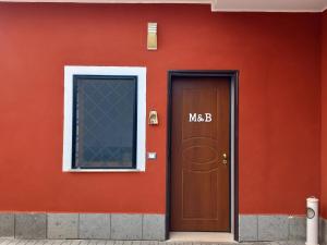 un edificio rojo con puerta y ventana en M&B, en Nettuno
