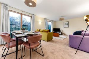 sala de estar con mesa, sillas y sofá en Scenic Park View Suite, en Milton Keynes