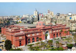 a large brick building in front of a city at Panorama New City in Cairo