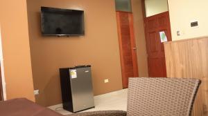 una stanza con televisore e due sedie e una porta di Marakos Pimentel a Pimentel