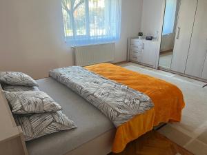 um quarto com uma cama com um cobertor laranja em Amma House Timisoara em Timisoara