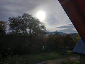 a view of the sun from the window of a house at Noclegi Żurawin in Lutowiska