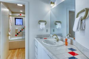 Baño blanco con lavabo y bañera en Remarkable Roundhouse Retreat, en Truckee