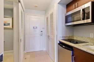 uma cozinha com um lavatório e uma porta branca em Studio Located at The Ritz Carlton Key Biscayne, Miami em Miami