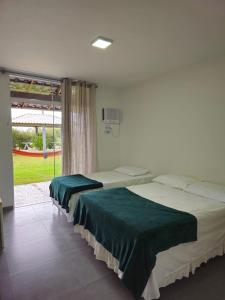 1 dormitorio con 2 camas con sábanas verdes en Capri Hotel en São Francisco do Sul