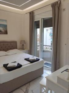 a bedroom with a bed with a view of a balcony at NAFPAKTOS Beach luxury Suites in Nafpaktos