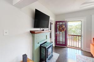 un soggiorno con camino e TV a schermo piatto di Madison Cottage a San Diego