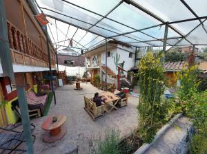 a patio with people sitting at tables under a greenhouse at KanchayKillaWasi in Chincheros
