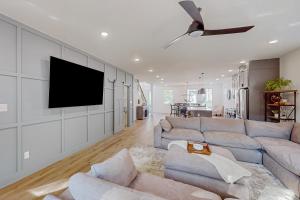 uma sala de estar com um sofá e uma televisão de ecrã plano em Indianapolis Gem & Guest House em Indianápolis