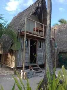 una casa en la playa con techo de paja en Cabana família coruja, en Camaçari