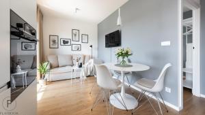 a living room with a white table and chairs at City Center SPA Apartments Pool & Parking in Gdańsk