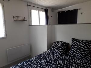 een kleine slaapkamer met een bed en een raam bij A Vol d'oiseau in Méreau