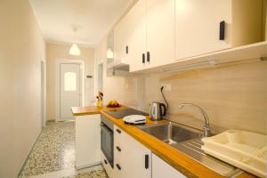 a kitchen with white cabinets and a sink at Itea Home in Itea