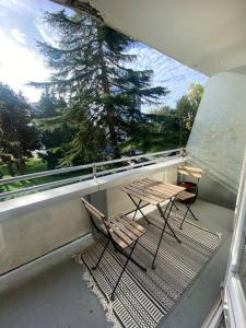 een balkon met 2 stoelen, een tafel en een boom bij T2 Haut Standing, hypercentre terrasse ascenseur in Tourcoing