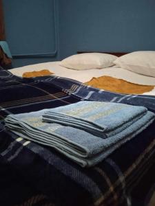 two folded towels sitting on top of a bed at Guest house Meri Poppins in Dedoplis Tskaro