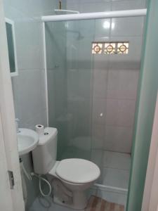 a white bathroom with a toilet and a sink at Pousada da Rotatória in São Gonçalo do Amarante